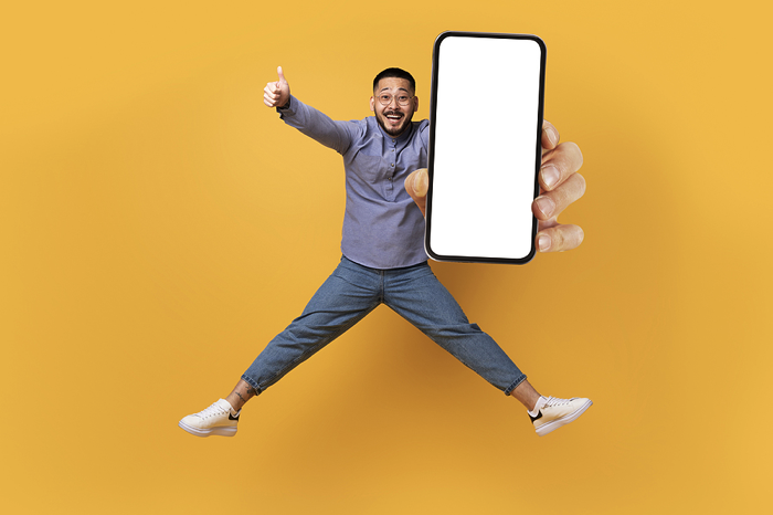 Happy man jumping with smartphone